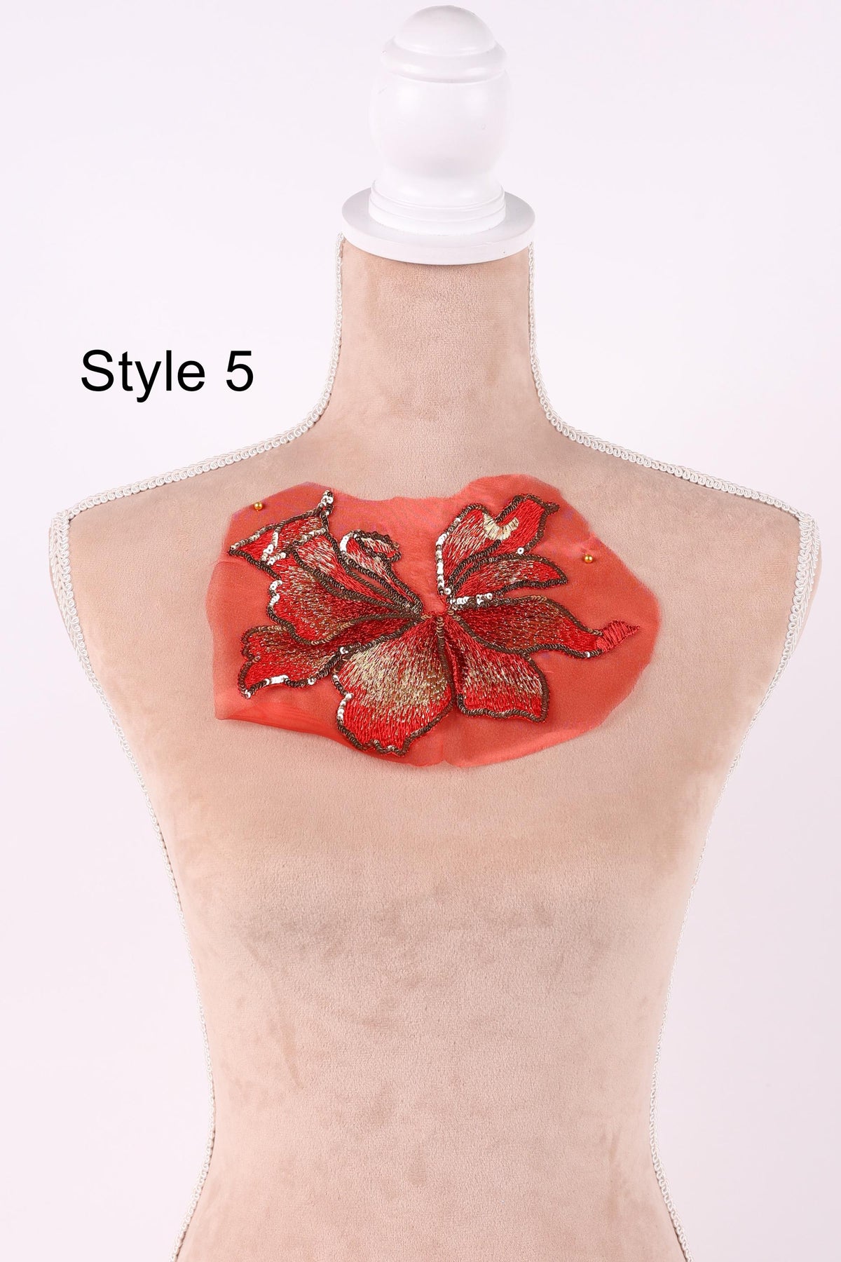 A mannequin with a red flower embroidered on its chest.