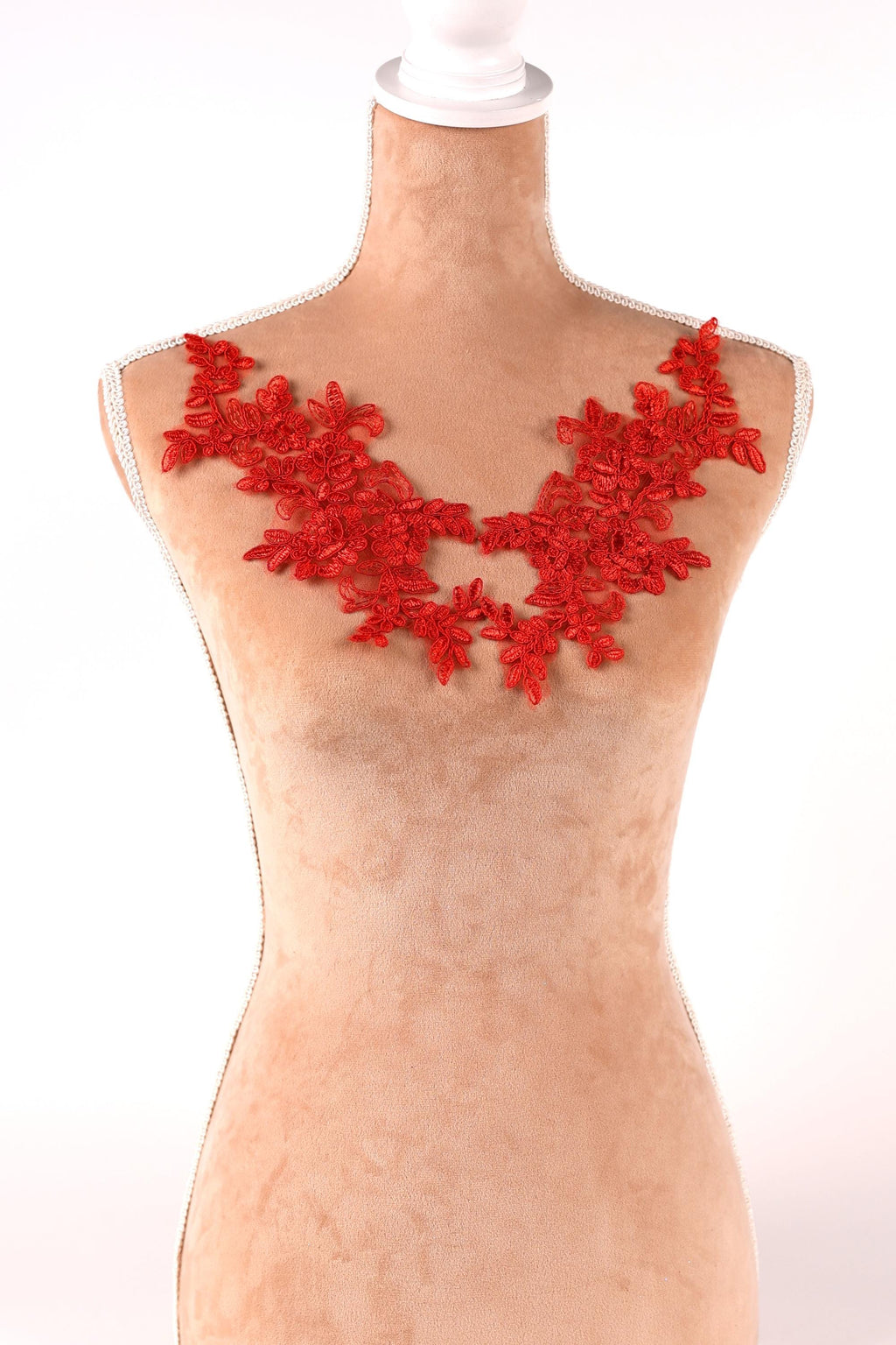 A mannequin wearing a red lace necklace with red flowers.