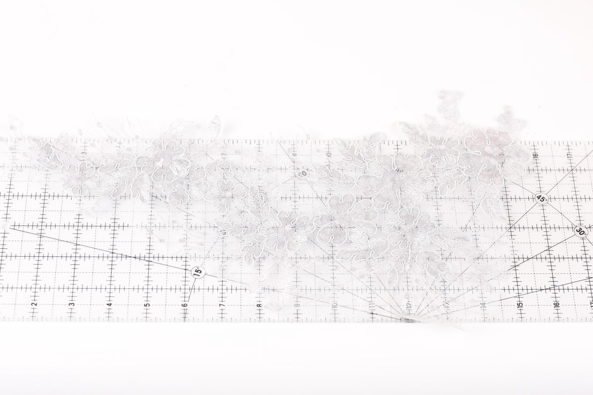 a close-up view of a white lace fabric with a grid pattern on a white background.