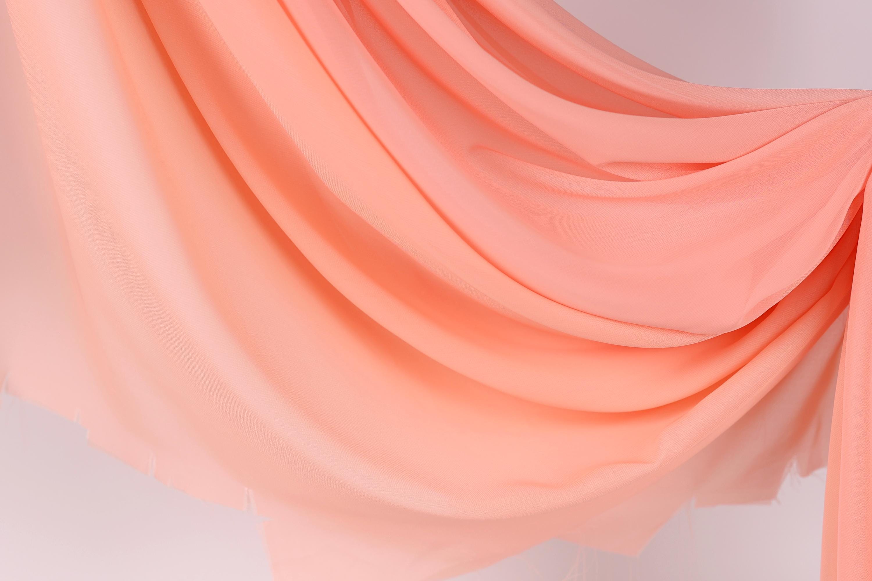 a flowing, draped fabric in a soft, peach-colored hue.