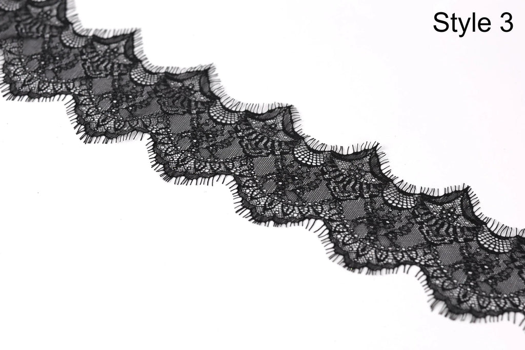 A close-up view of a black lace trim with intricate patterns and textures.