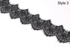 A close-up view of a black lace trim with intricate patterns and textures.