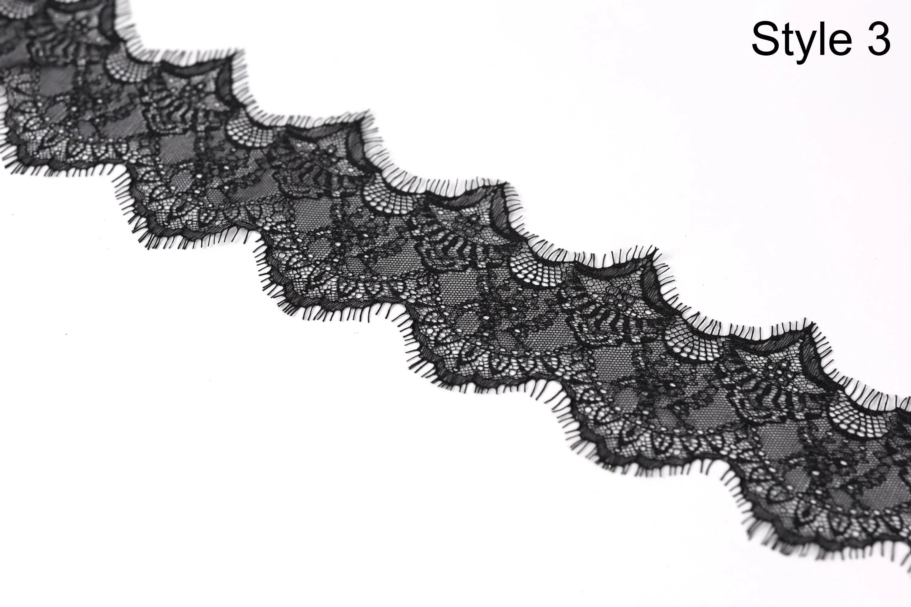 A close-up view of a black lace trim with intricate patterns and textures.