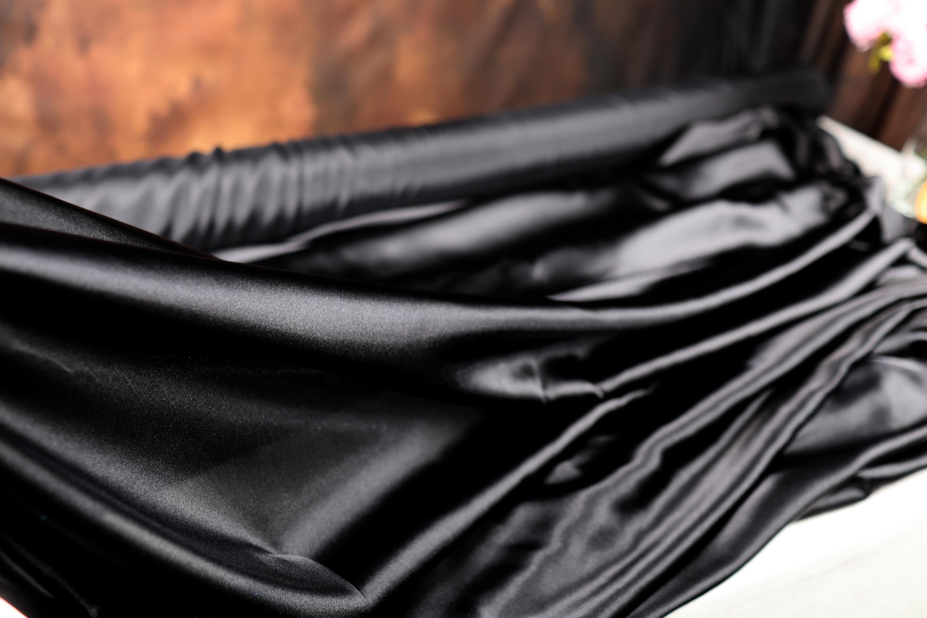 a close up of a black cloth on a bed