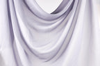 The image is a close-up of a white fabric, possibly a sheer or sheer-like material, with a soft, flowing texture.