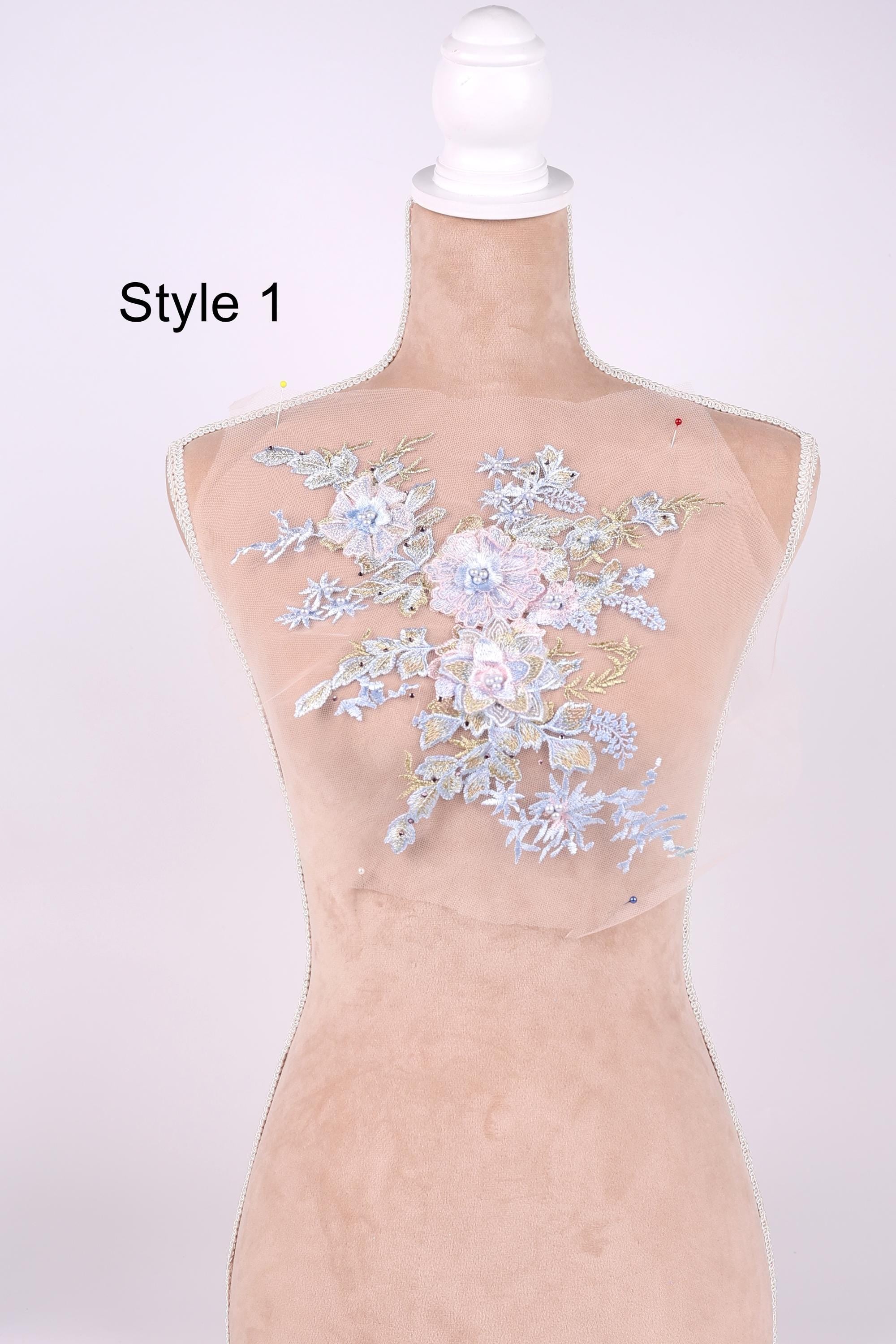 A mannequin with a floral embroidered patch on its bust, featuring a variety of delicate flowers in shades of blue and white.