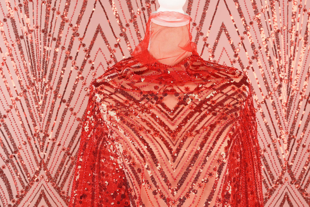 a mannequin wearing a red sequin dress with a geometric pattern.
