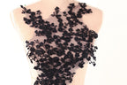 A mannequin wearing a dress with a black lace bodice featuring a floral pattern.
