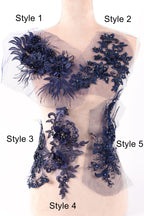 A mannequin with various blue lace and floral embroidery pieces attached to its torso, showcasing different styles and designs.
