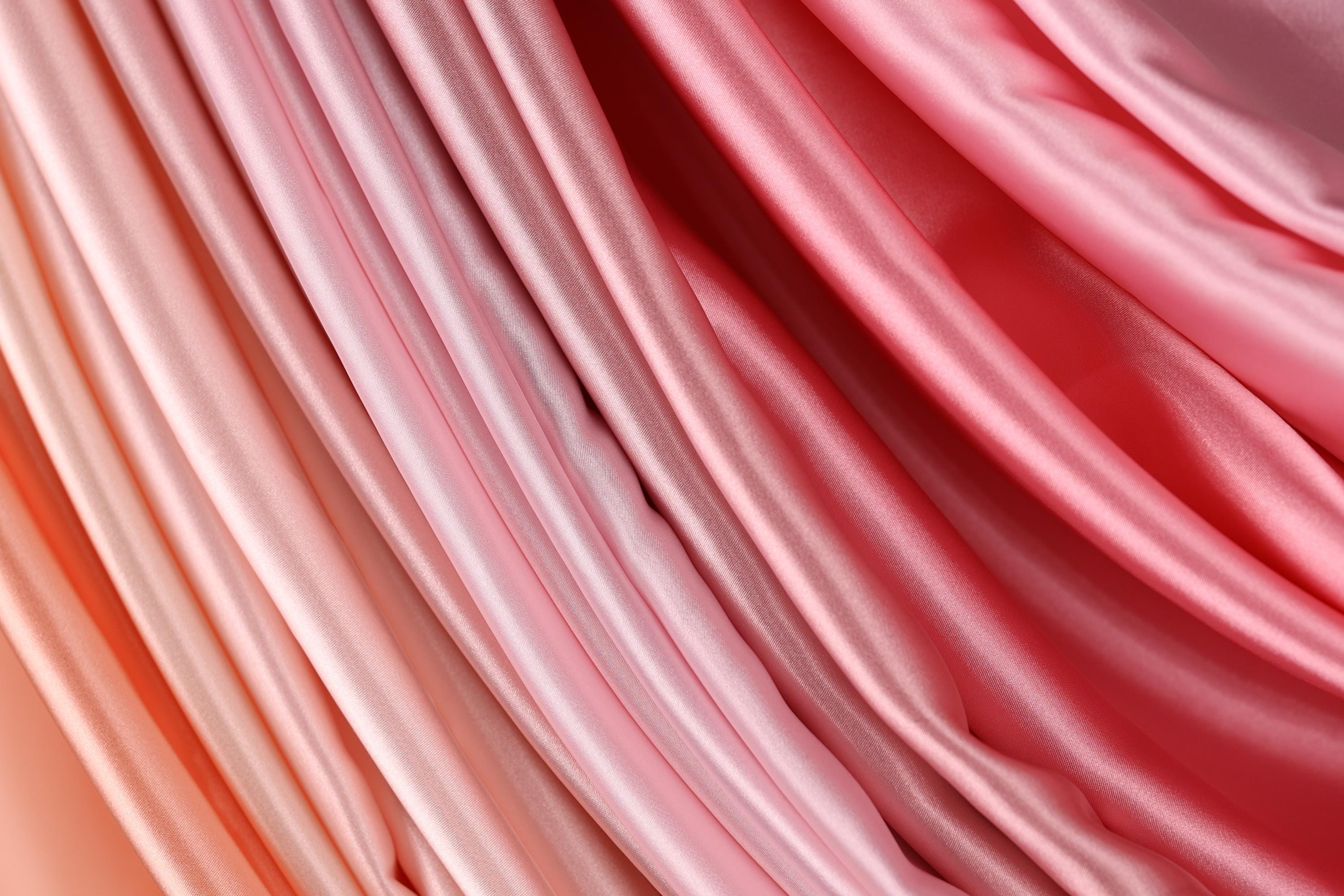 a close-up view of a fabric with a gradient of pink and orange colors, creating a visually appealing and textured appearance.