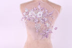 A mannequin with a delicate, floral-patterned fabric draped over its back.