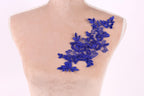 A mannequin torso with a decorative blue lace pattern on the shoulder.