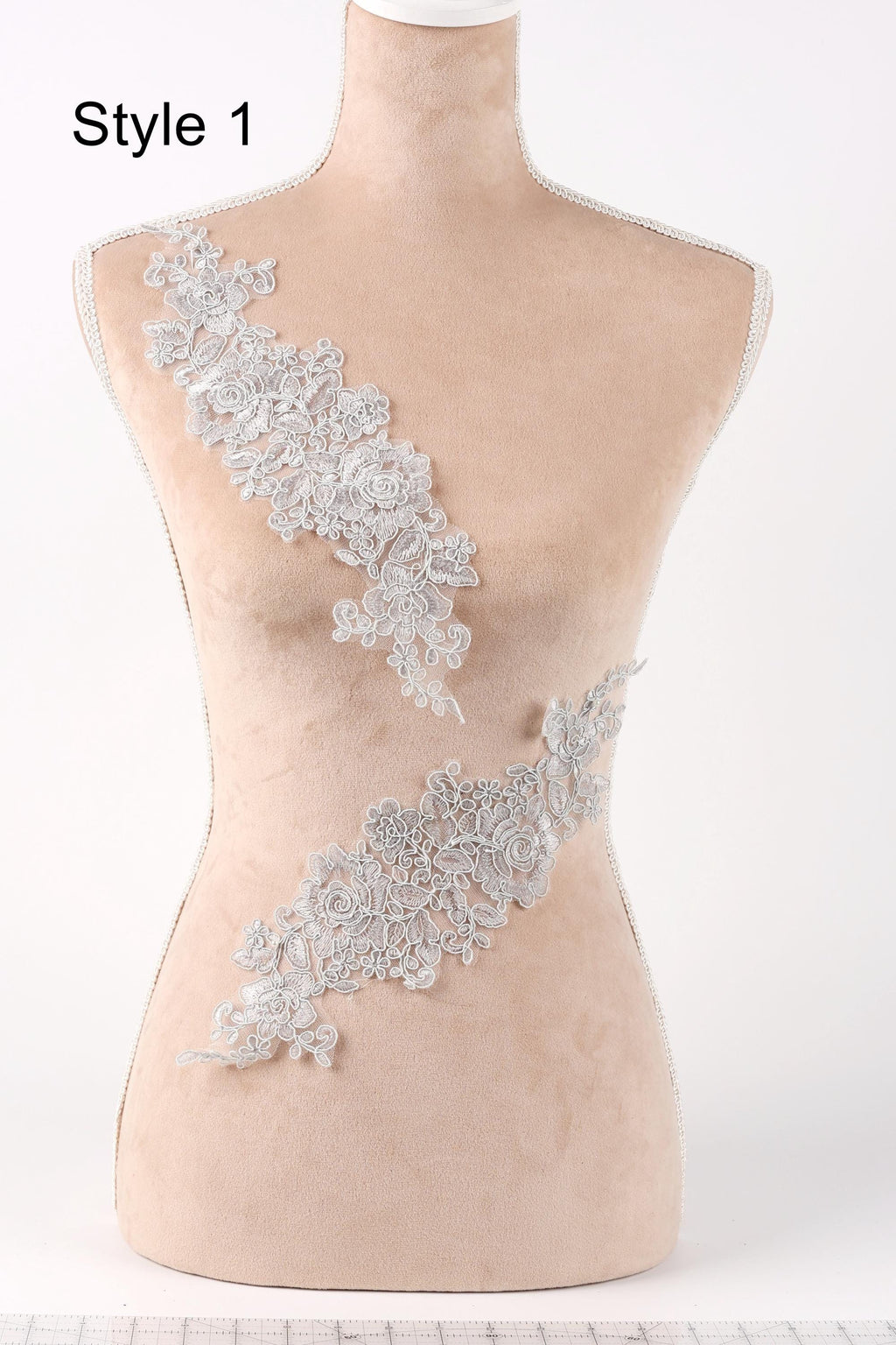 A mannequin with a beige body and a white lace overlay on its torso.
