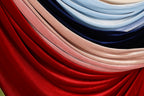 a close-up view of a collection of colorful fabric swatches, including red, pink, blue, and black.