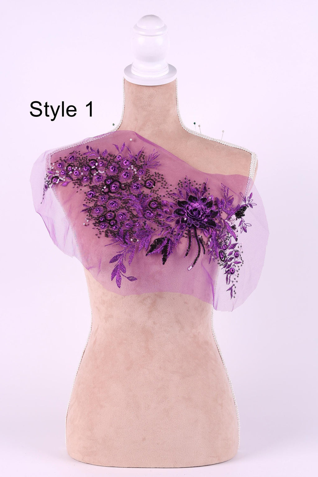 A mannequin with a pink floral design on its chest, featuring purple flowers and leaves.
