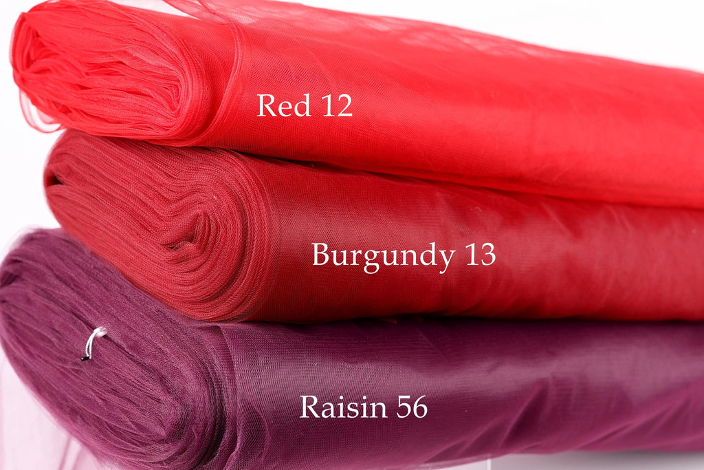 three different colored fabric rolls stacked on top of each other, with each roll labeled with a different color and size.
