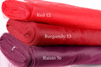 three different colored fabric rolls stacked on top of each other, with each roll labeled with a different color and size.