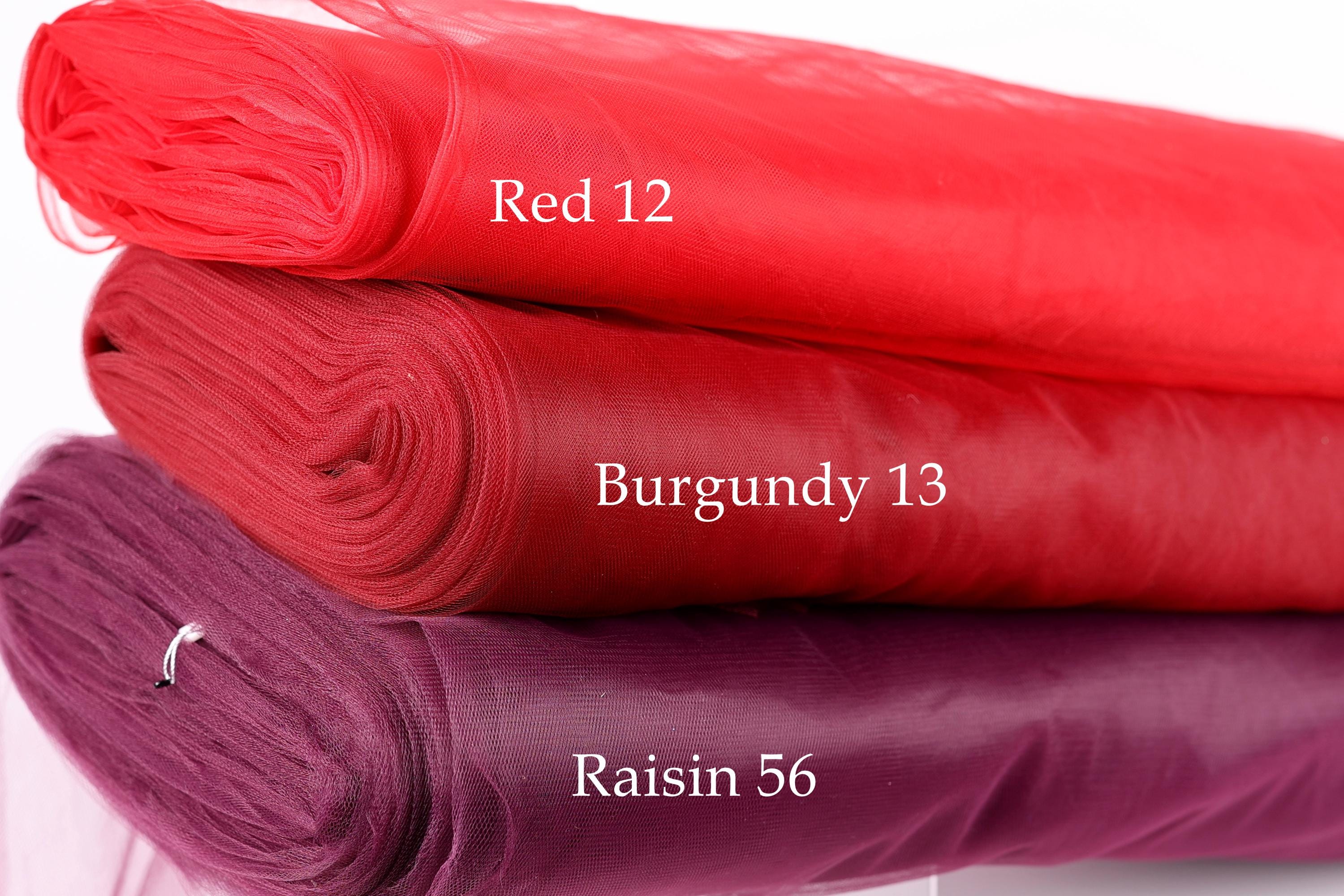 three different colored fabric rolls stacked on top of each other, with each roll labeled with a different color and size.