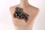 A mannequin bust with a decorative piece of fabric or material on it, featuring a floral pattern.
