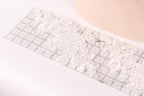 a clear ruler with a floral pattern on it, placed on a white surface.