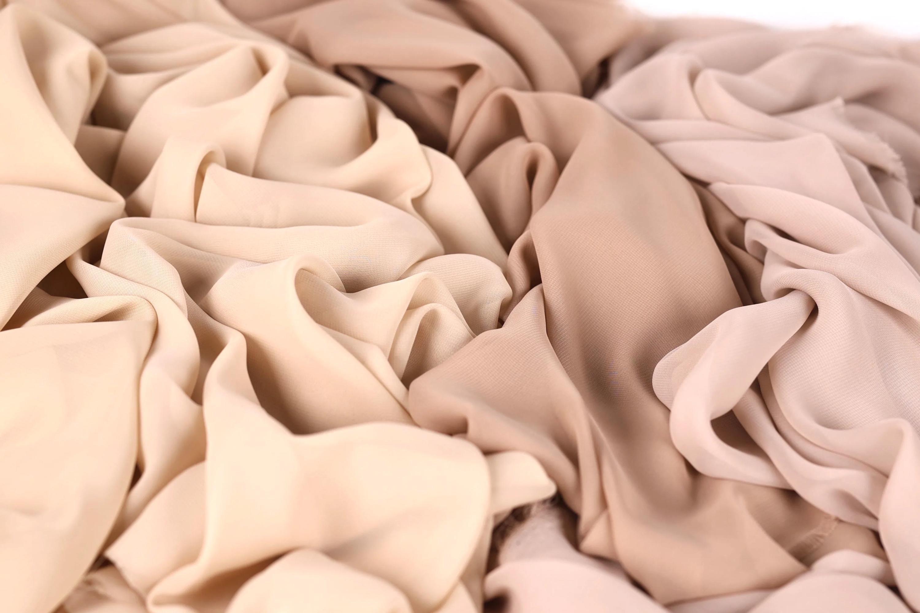 a close-up view of a crumpled fabric with a light brown or beige color.