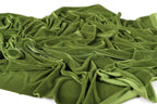 a close-up view of a crumpled, green fabric, possibly velvet, with a textured and wrinkled appearance.