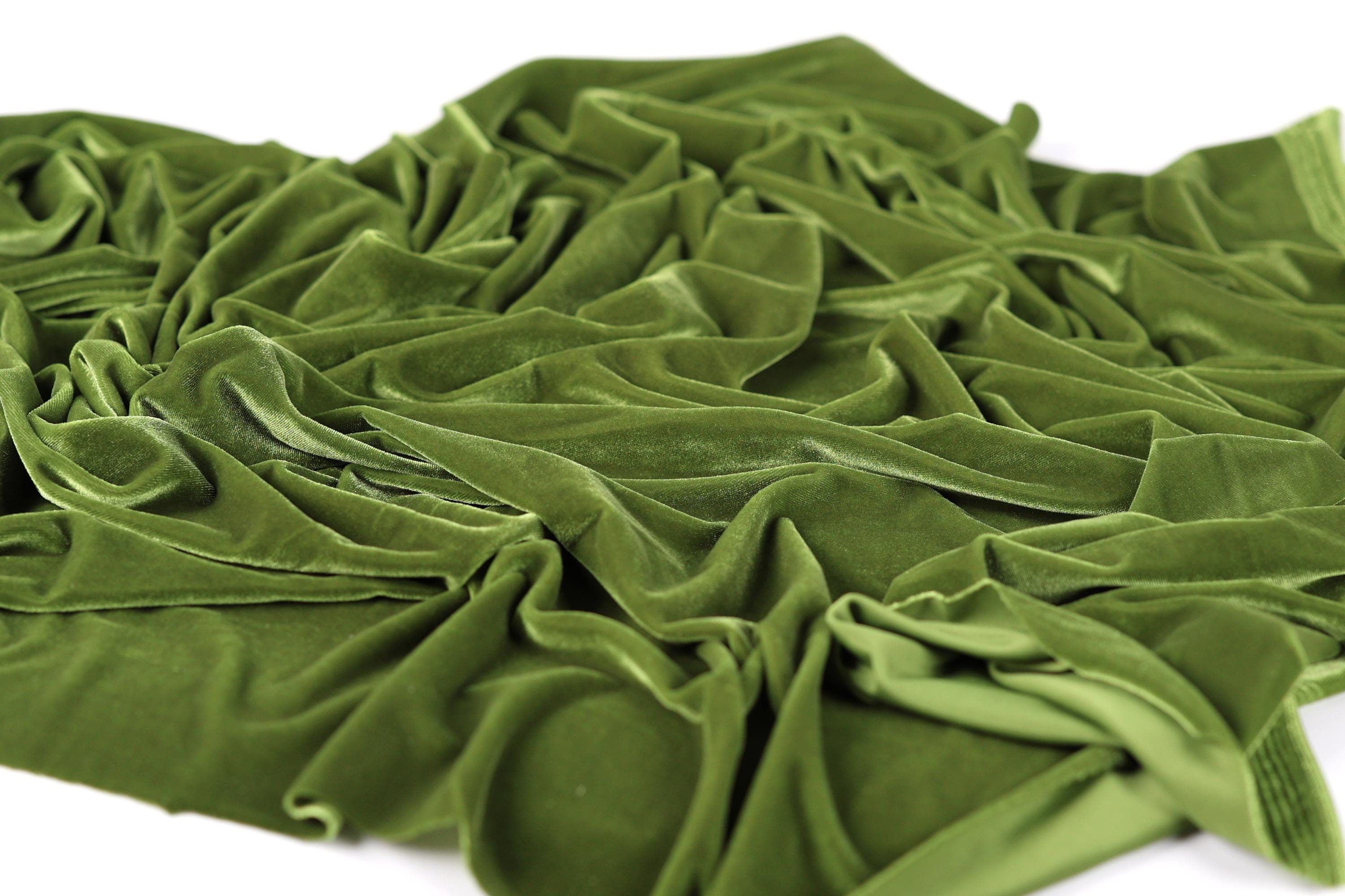 a close-up view of a crumpled, green fabric, possibly velvet, with a textured and wrinkled appearance.