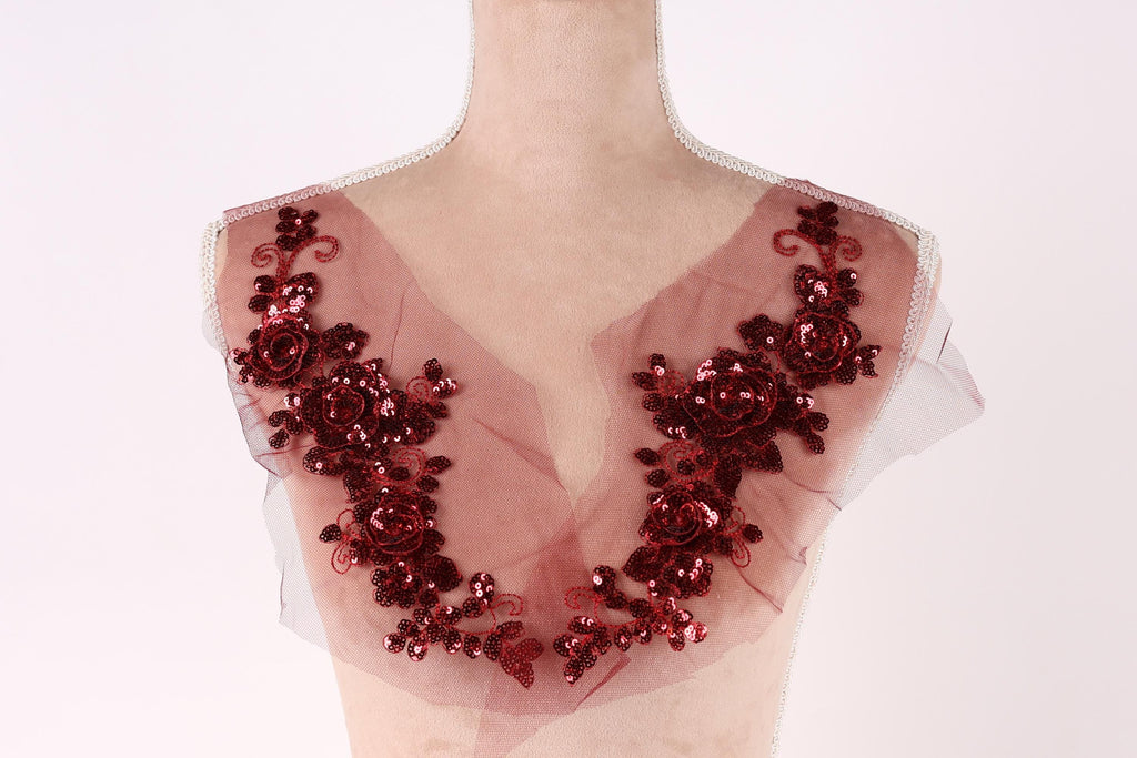 A mannequin wearing a red sequin and floral-embellished dress.