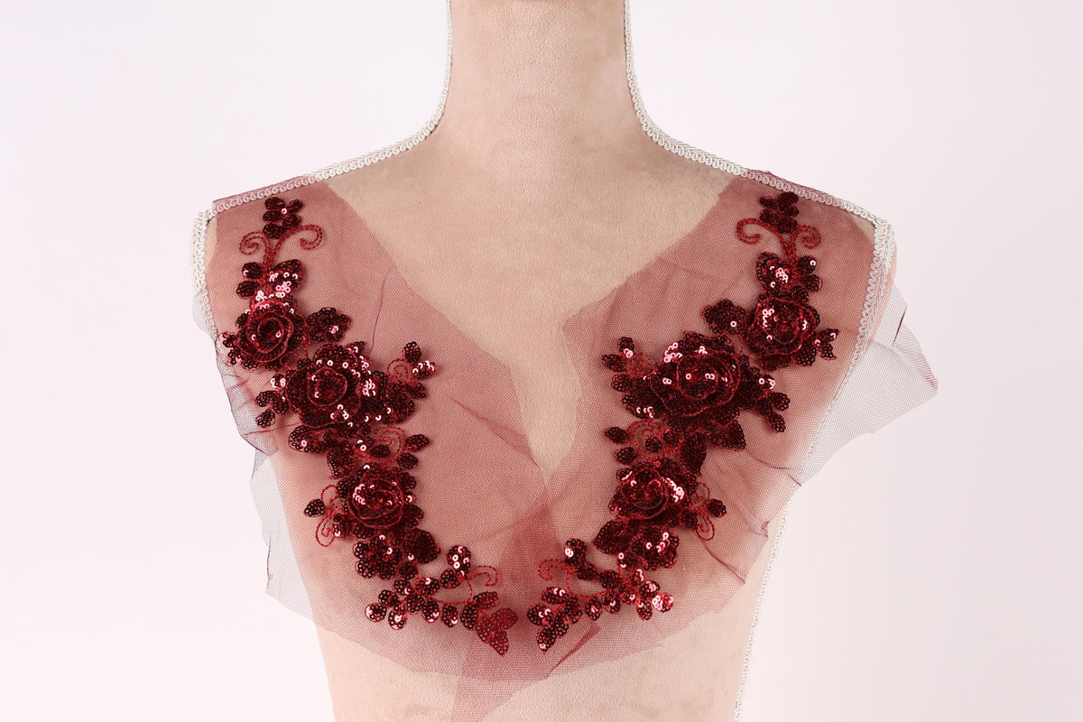 A mannequin wearing a red sequin and floral-embellished dress.