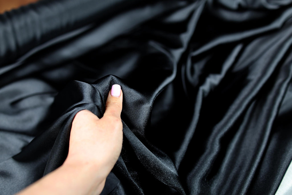a woman&#39;s hand on a black cloth