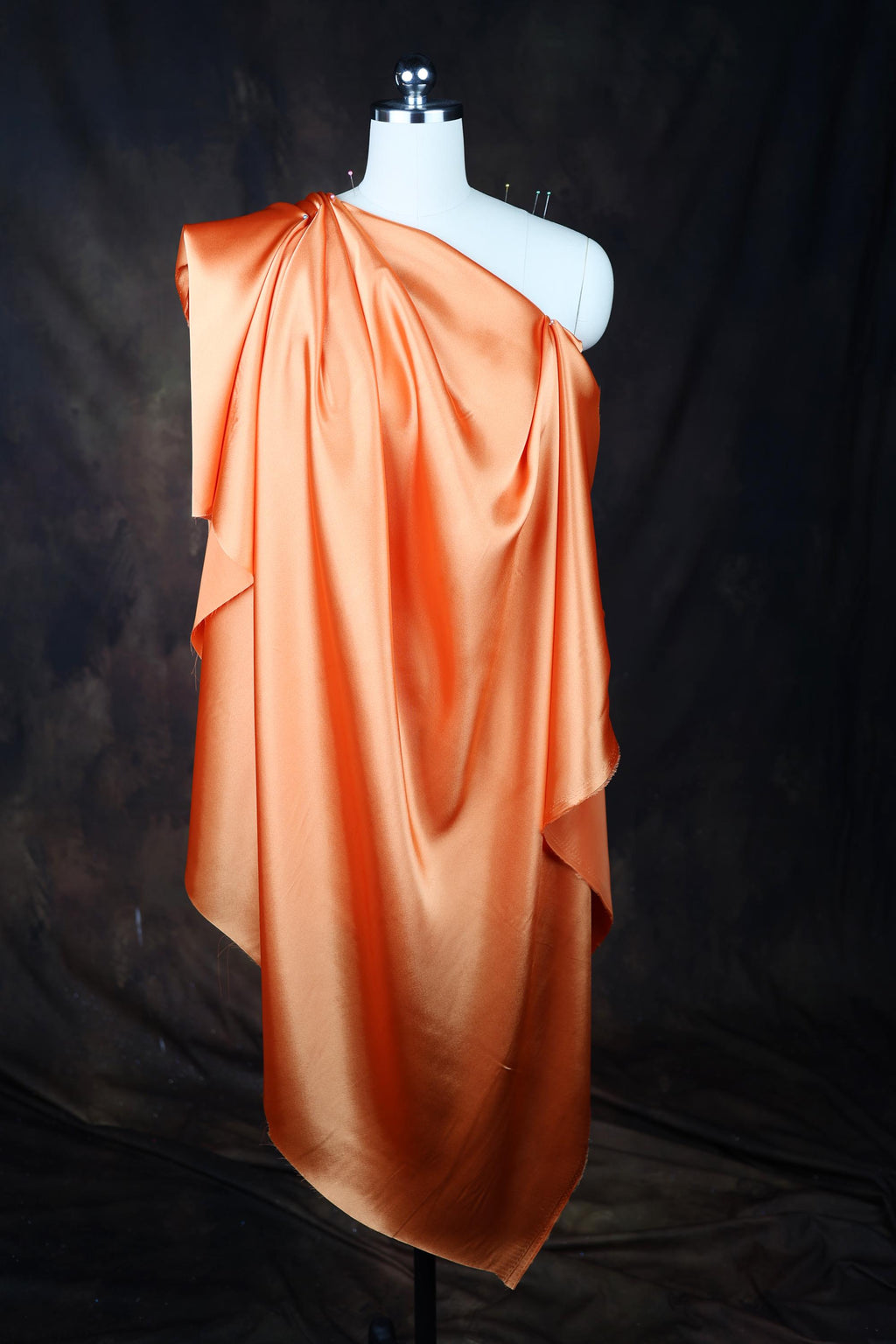 an orange dress on a mannequin on a black background