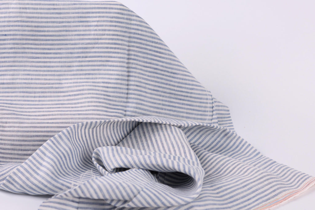 A close-up view of a fabric with a striped pattern in shades of blue and gray.