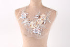 A mannequin with a delicate floral embroidered piece of fabric on its bust.