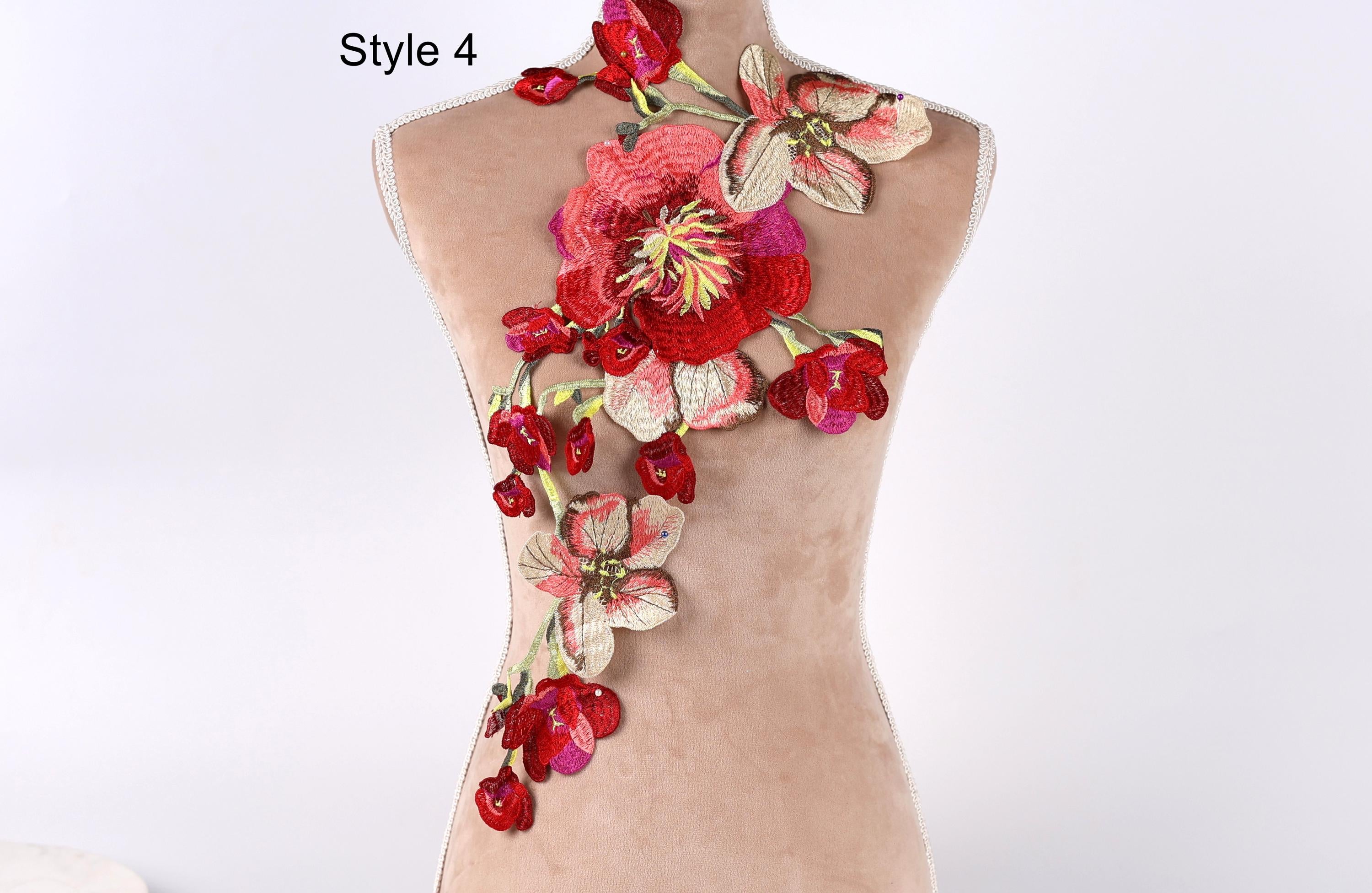A mannequin with a floral embroidered design on its back, featuring red and pink flowers.