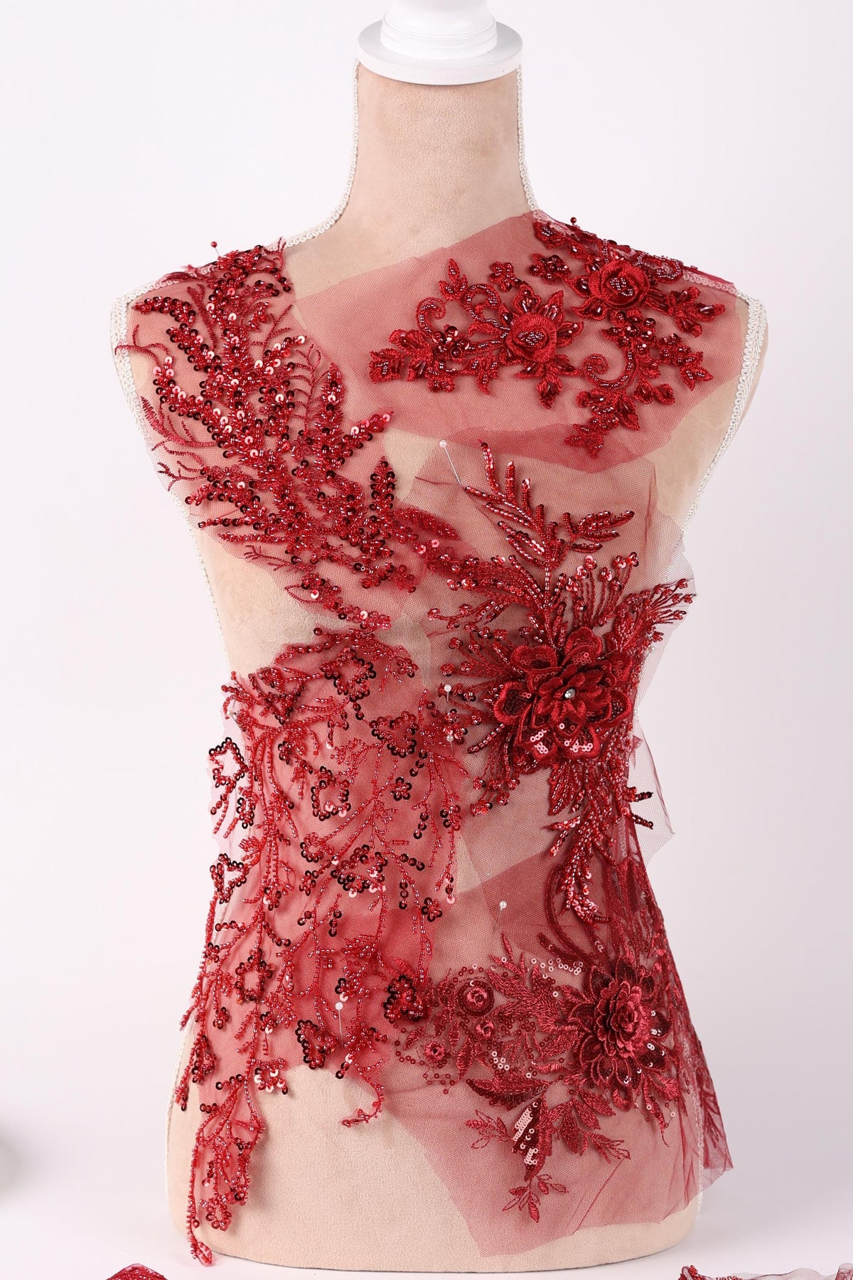 a red dress with intricate embroidery and embellishments, including a floral pattern and sequins.