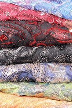 a collection of colorful, patterned fabric rolls or swatches, each with a unique design and color scheme.