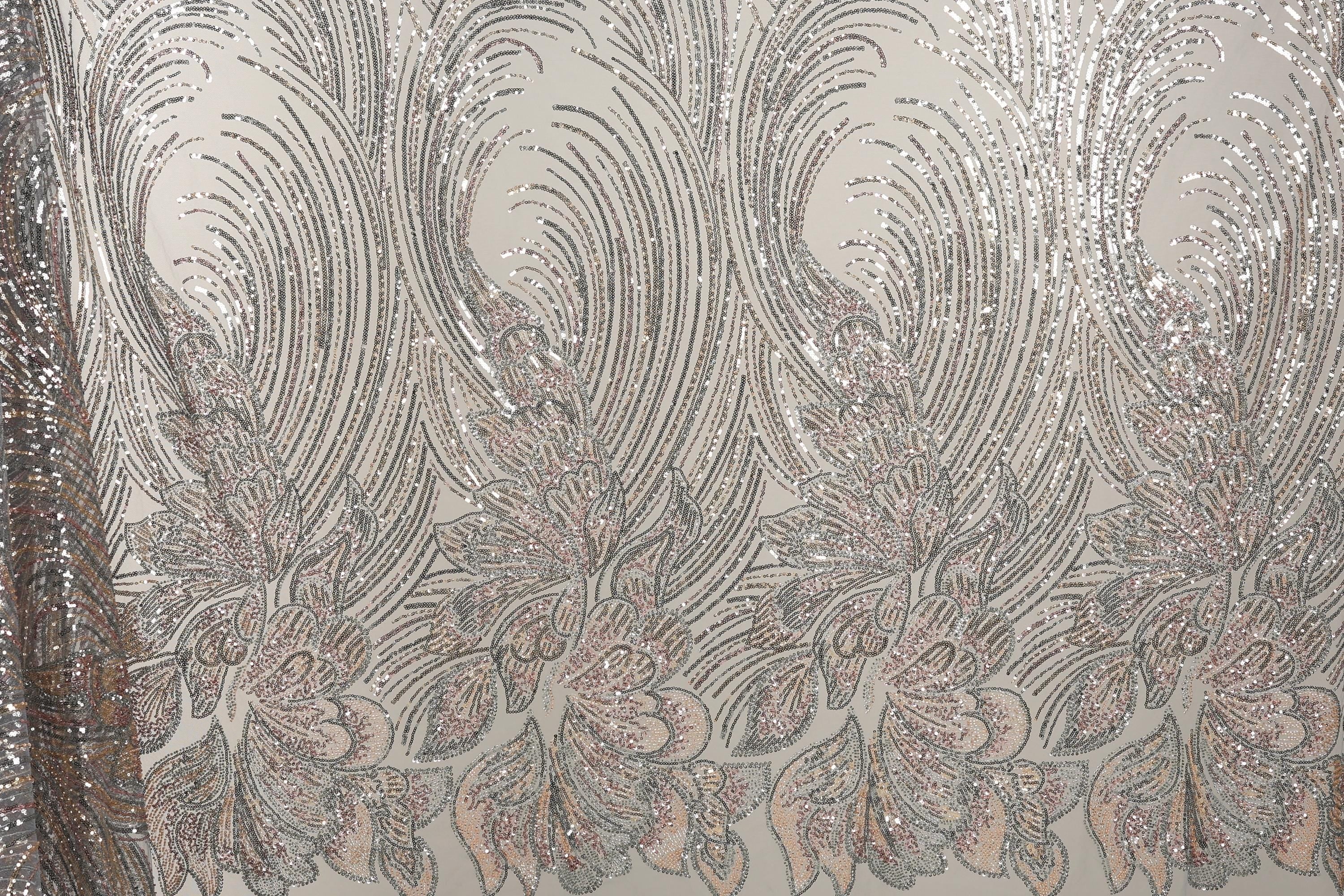 a close-up view of a fabric with a repeating pattern of silver and pink sequin designs. The pattern consists of various shapes and sizes of sequins arranged in a decorative manner, creating a visually striking and intricate design.