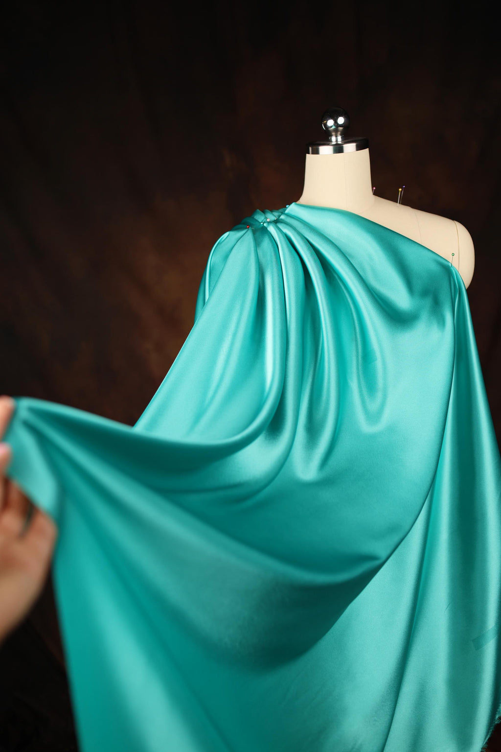 a mannequin wearing a blue dress with a cape on top of it