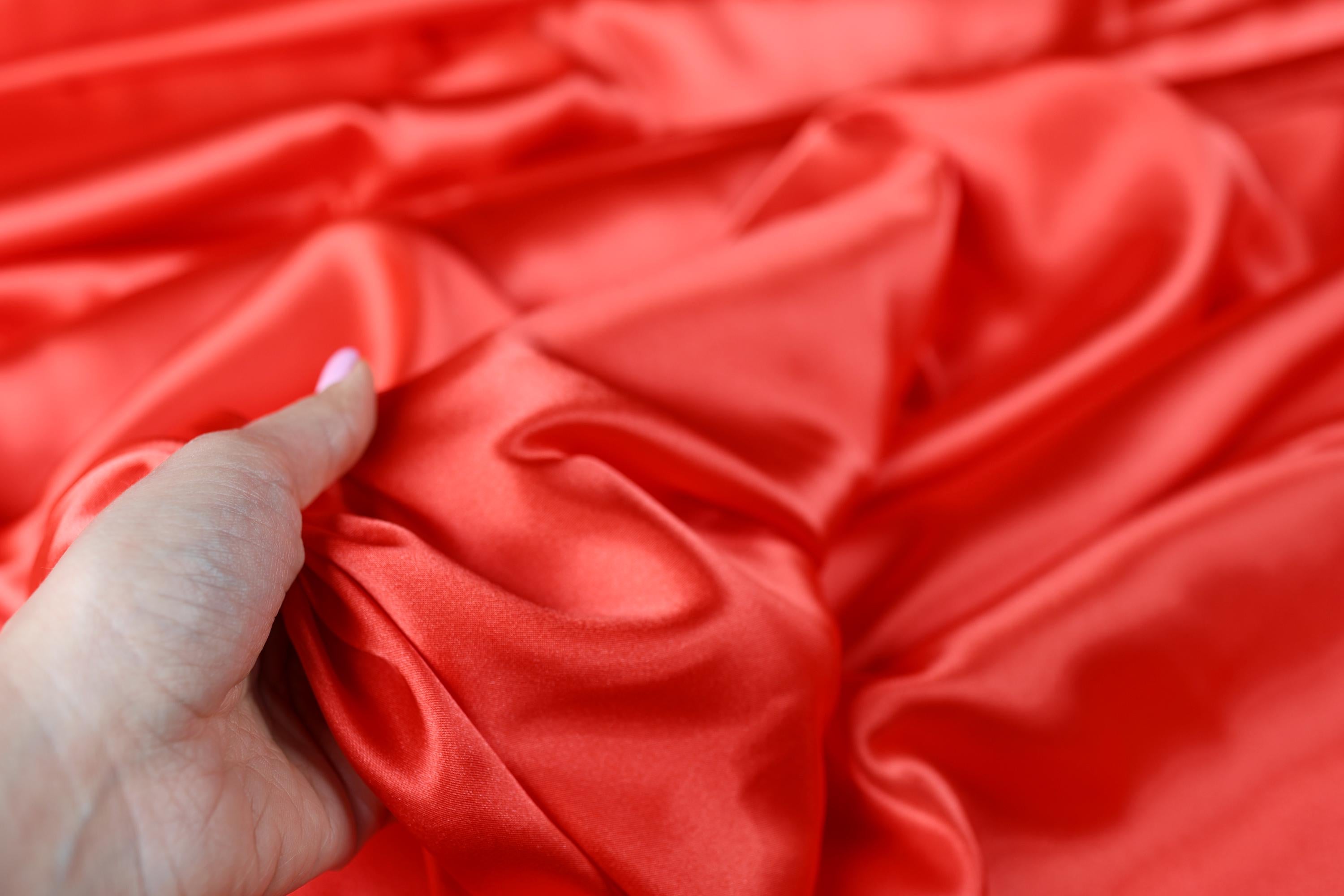 a person is holding a red cloth with a white tip