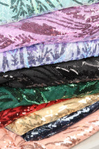 A close-up view of a stack of colorful fabric pieces with sequin patterns, showcasing various shades and textures.