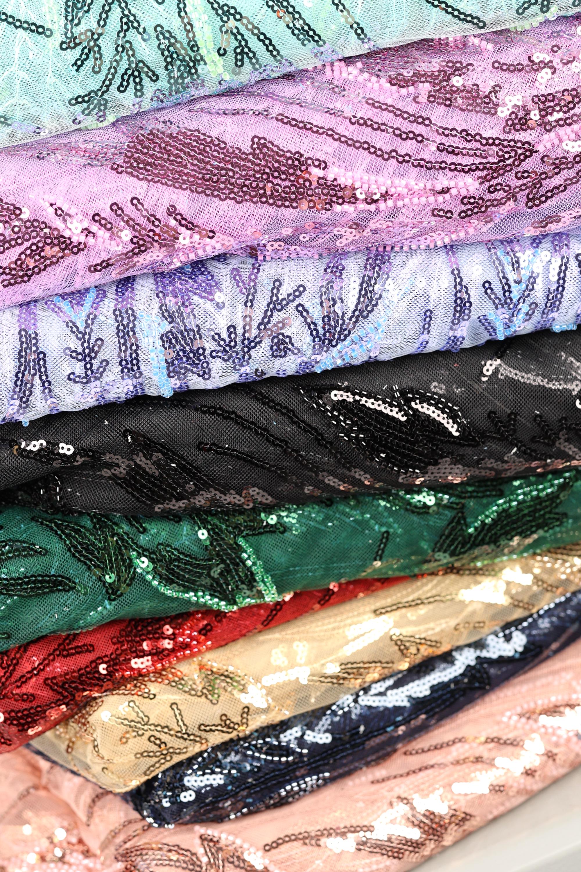 A close-up view of a stack of colorful fabric pieces with sequin patterns, showcasing various shades and textures.