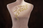 A mannequin wearing a delicate gold necklace with small yellow flowers.