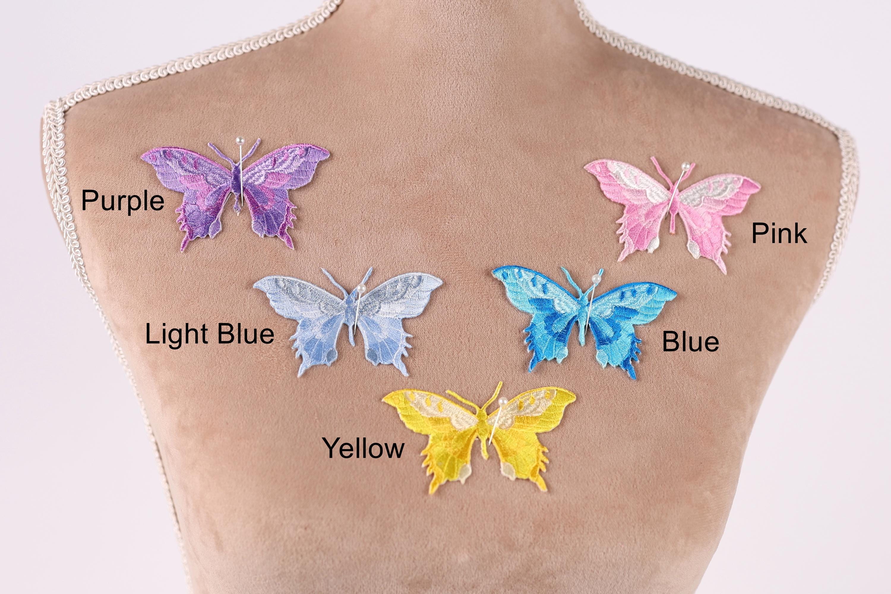a mannequin torso with five colorful butterfly patches on it, each with a different color and design.