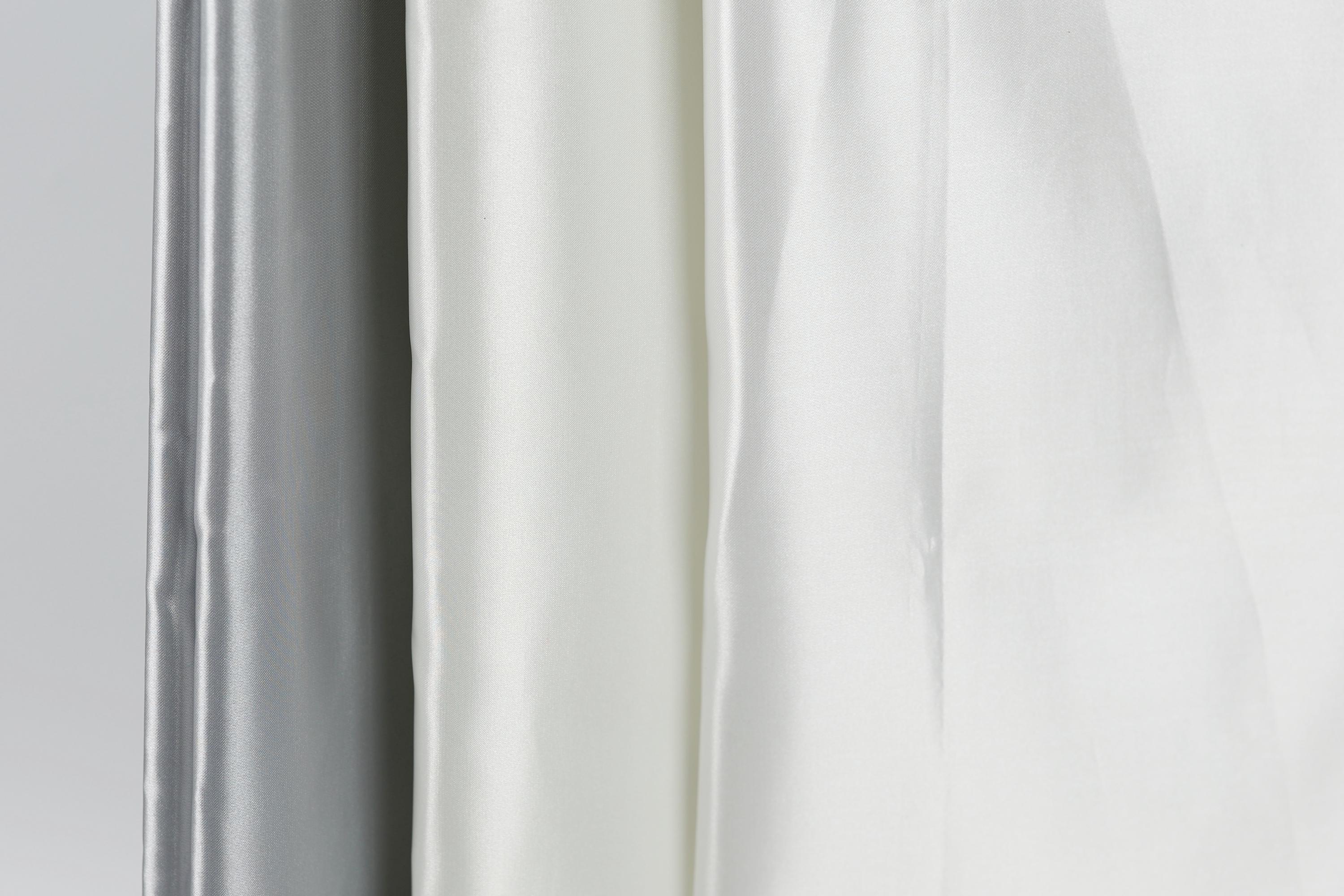 a close-up view of three fabric swatches, with the middle one being white and the other two being gray.