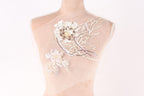 A mannequin with a delicate, intricate floral embroidery on its shoulder.