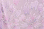 a close-up view of a patterned fabric with a floral design. The fabric has a pink and purple color scheme, and the pattern includes various shapes and textures, such as leaves, flowers, and other organic elements. The image does not contain any text or countable objects, and the focus is on the intricate and visually appealing design of the fabric.