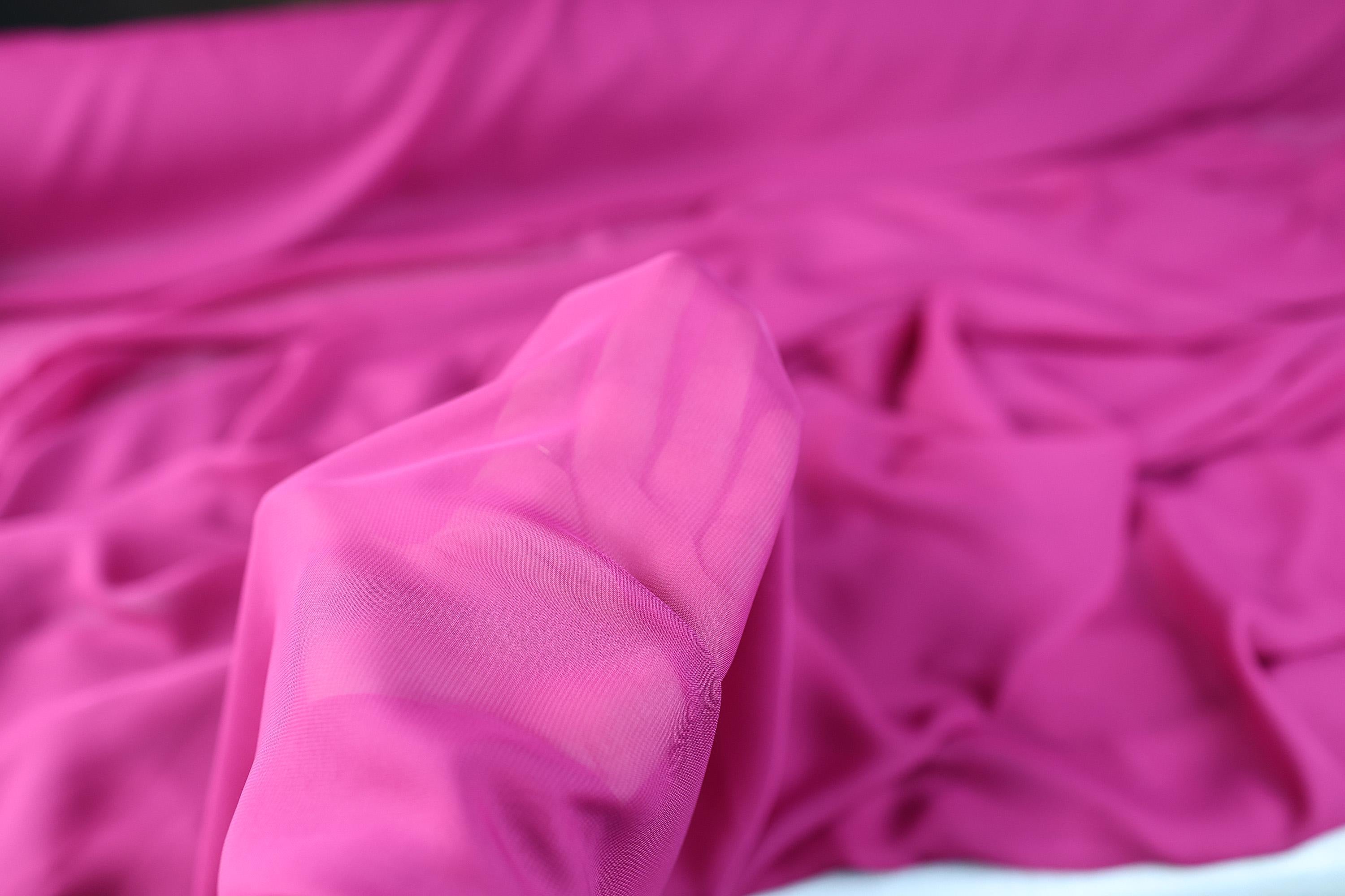 a close up of a bed with pink sheets