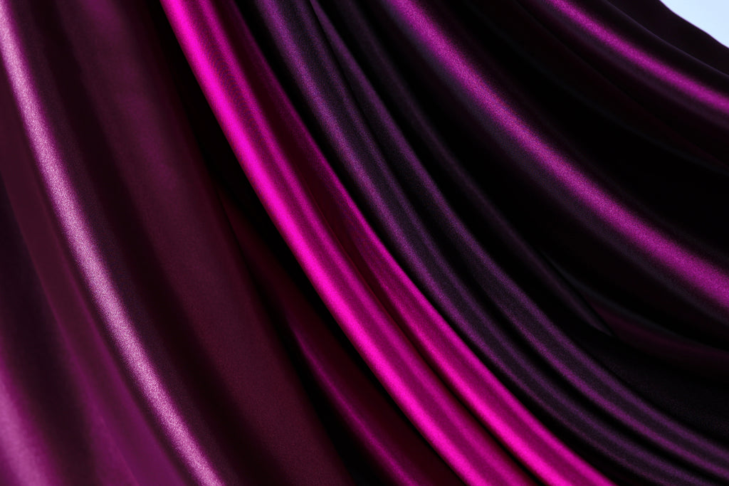 a close-up view of a fabric with a purple and pink color gradient, creating a visually striking and vibrant pattern.