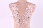 A mannequin with a pink floral lace design on its shoulders.