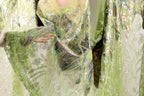 A close-up view of a green and silver sequined dress or garment, with intricate patterns and designs.